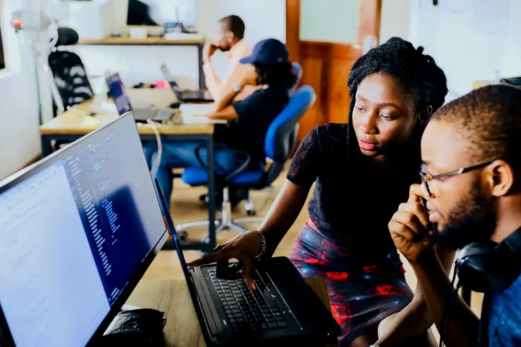 Students learning to code together at a computer